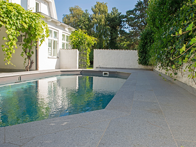 Hus med pool med granit som marksten och poolkant i granitsten runt poolen.