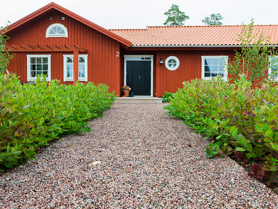 Grusgång med gårdssingel framför lantligt hus