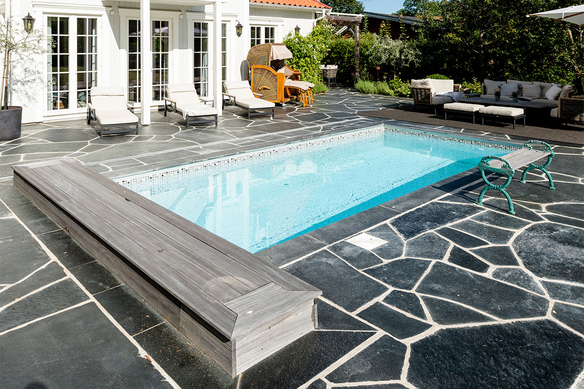 Skiffer runt pool på baksida av ett hus