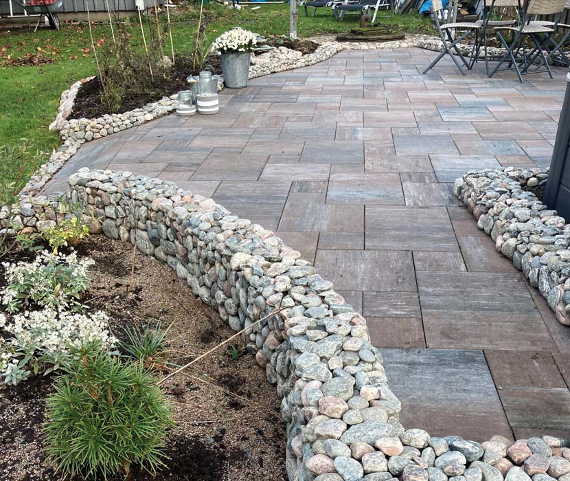 Stenbelagd uteplats med murar av naturstenar.