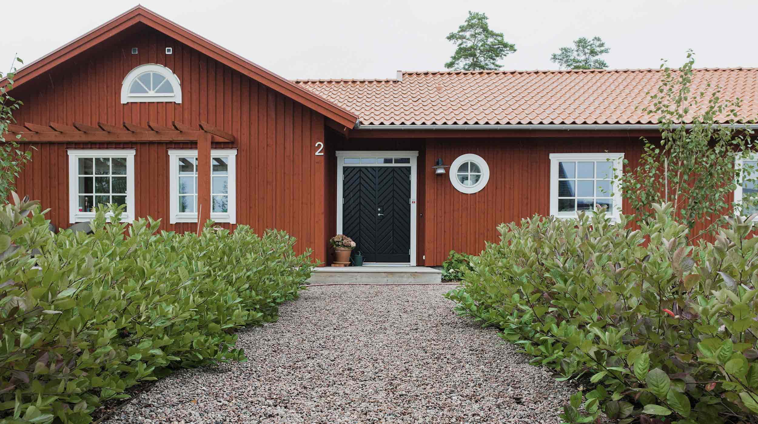 Grusgång med gårdsgrus. Gången går upp mot ett rött hus.
