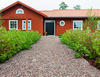 Grusgång med gårdssingel framför lantligt hus